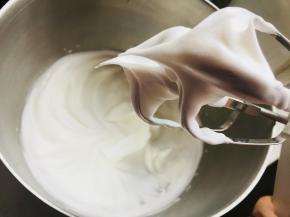 蛋黄中加入柠檬汁，分三次加入糖，打发至小弯钩。