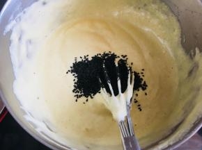 再将它全部倒回蛋白中，翻拌均匀后，加入黑芝麻