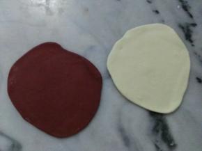 白面团平均分成两块。
分别将其中一块白面团擀平，再将红面团擀平。