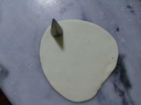 现在来做金针菇，把刚才分出来的白面团，擀平。用模具压出小圆。