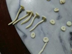 长条要再搓一搓，成圆柱体。长条要长短不不一，才好看。小圆，中间戳一下洞，沾水贴上长条，金针菇就出来了。