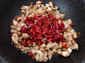 转最小火加入干辣椒和干花椒，慢慢翻炒出辣椒花椒飘出香味