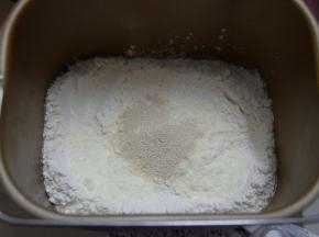 将除黄油外的其他食材全部倒入面包桶中，酵母避免与水和盐接触，启动面包机揉面功能