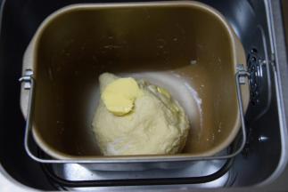 面团不粘手的时候，分次加入黄油，继续揉面