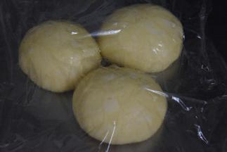 压出大气泡，分成三等份后盖上保鲜膜醒发二十分钟