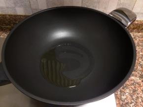 热锅倒油烧至八成热。