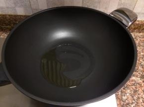 热锅倒油烧至八成热。