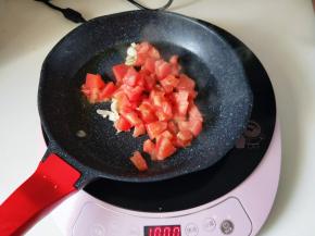 再起油锅，加入切好的蒜炒香，再加入番茄块煸炒。