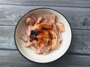 将鸡翅尖用剪刀剪成两半，加入适量蚝油、生抽、五香粉拌匀腌制一会儿。