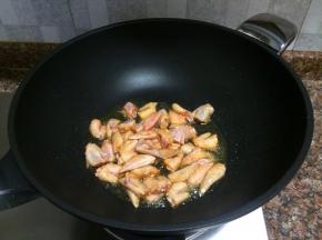 放入鸡翅尖翻炒至熟透，并且表面微微发黄。