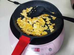 将打散的蛋液倒入锅中，小火力煎鸡蛋饼，再用铲子切碎，盛出备用。