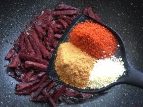 放入两勺辣椒粉，三勺小丑娃孜然粉，一勺鸡精翻炒均匀。