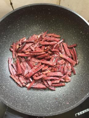 倒入切好的牛肉条中小火慢慢的煸炒至微焦。