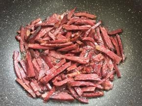 倒入切好的牛肉条中小火慢慢的煸炒至微焦。