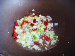 不粘锅里倒入食用油，放入葱和干辣椒煸香。