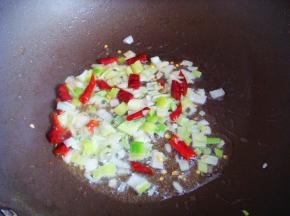 不粘锅里倒入食用油，放入葱和干辣椒煸香。