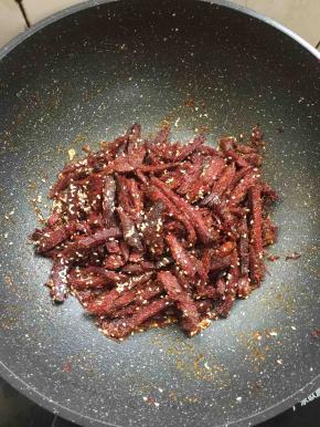 放入适量的白芝麻翻炒片刻。