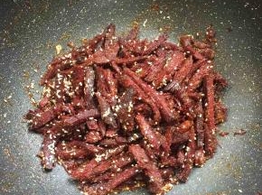 放入适量的白芝麻翻炒片刻。