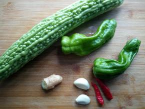 将所需食材洗净备用，苦瓜去瓤切片，辣椒切长条。