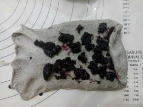面团擀成牛舌形铺上桑葚酱卷起来。盖保鲜膜松弛15分钟。