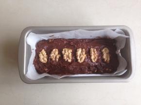 长条形模具里铺上油纸（我使用的是法焙客17CM长条形蛋糕模），将蛋糕面糊倒入，刮平表面，放上核桃仁