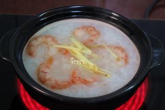 白粥熬好之后，放入腌制好的虾仁、生姜丝；可以把腌制的汁一起倒入更鲜美