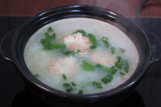 改为大中火，开着盖继续煮，千万别盖盖子，非常容易溢出。不断用勺子搅拌，虾仁煮熟，放入香葱、盐，拌均。