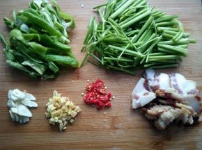 野芹菜切段，辣椒切条，蒜切片，姜切末，小米椒切小段，腊肉切片。