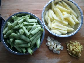 豆角用手掰断，土豆切粗的长条，蒜切片，姜切末。