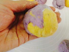 取一个南瓜小面团和一个紫薯小面团揉圆混成一个面团