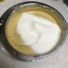 筛入一半的低粉，翻拌均匀后筛入另一半，翻拌至无干粉状态。