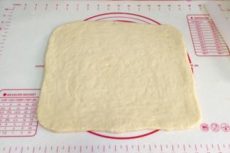 取出冷冻松弛好的面片，继续擀开，刷上一层炼乳。