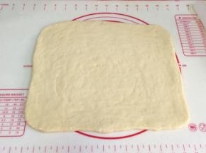 取出冷冻松弛好的面片，继续擀开，刷上一层炼乳。