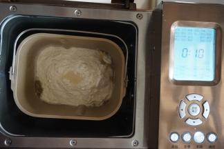 在面粉顶端加酵母，将面包桶放入面包机里