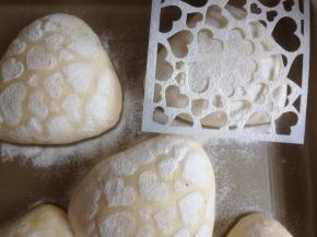 发酵好的面包坯上盖一张图案板，撒上面粉