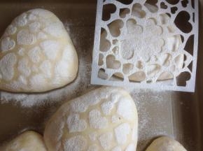 发酵好的面包坯上盖一张图案板，撒上面粉