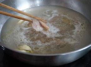 锅里的水烧开后，放入姜、蒜、花生油，加入瘦肉片