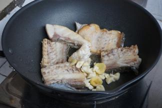 将鱼煎至两面金黄，放入姜蒜