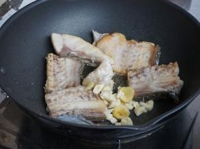 将鱼煎至两面金黄，放入姜蒜