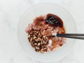 在肉馅中加入切碎的香菇粒、鸡蛋清、生抽、蚝油、盐、糖和五香粉，用筷子朝一个方向搅拌上筋。