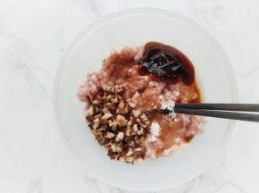 在肉馅中加入切碎的香菇粒、鸡蛋清、生抽、蚝油、盐、糖和五香粉，用筷子朝一个方向搅拌上筋。
