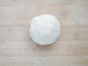 在面粉中加入蛋清水，先用筷子搅拌成雪花状，再用手揉成团。将面团上覆盖保鲜膜，醒30分钟松弛面筋。