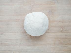 在面粉中加入蛋清水，先用筷子搅拌成雪花状，再用手揉成团。将面团上覆盖保鲜膜，醒30分钟松弛面筋。