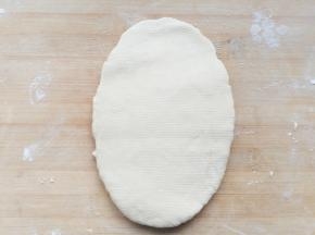 将醒好的面团，擀成厚的面片方便压面机操作。