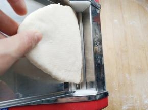 压面机调最大档，第一次压面。面皮出来了，对折后再压3－5次。这时面片越来越光滑。