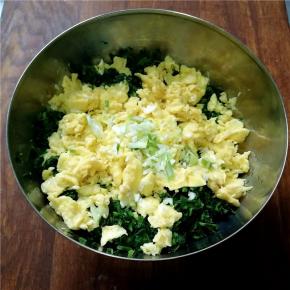 把炒好的鸡蛋和葱末放到苜蓿碎里。