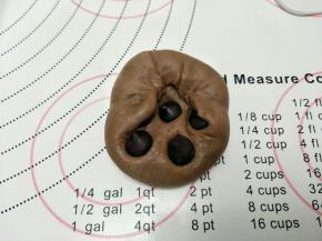 包入巧克力豆。四周往里捏住，最后收口。成圆形。