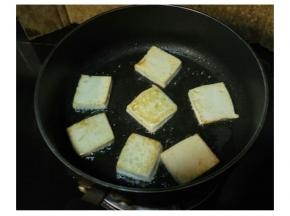 锅烧热倒入适量的油，锅底撒少量的蒜盐，放入豆腐，单面煎黄后翻面，将另一面煎黄