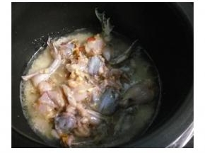 待煮至饭煲出水蒸汽，放入田鸡继续煮。