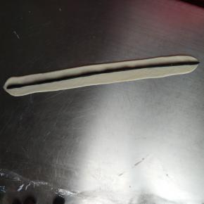 再取10克的白色面团擀长包裹黑色的面团卷起